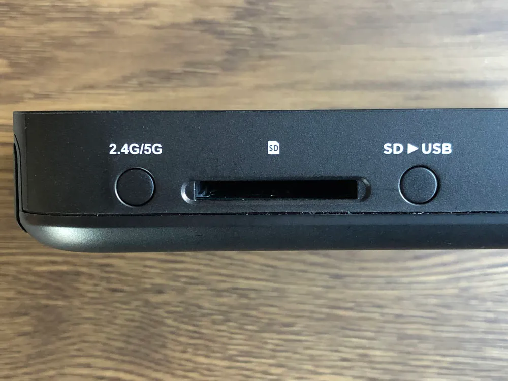 【RAVPower Filehub RP-WD009レビュー】スマホ写真&動画データを簡単バックアップ!無線でデータ共有もできるWi-Fi SDカードリーダー|旅行などに最適|外観:左側面には周波数を切り替えるボタン、SDカードスロット、SDカードからUSBにバックアップを行うためのボタンが配されています。